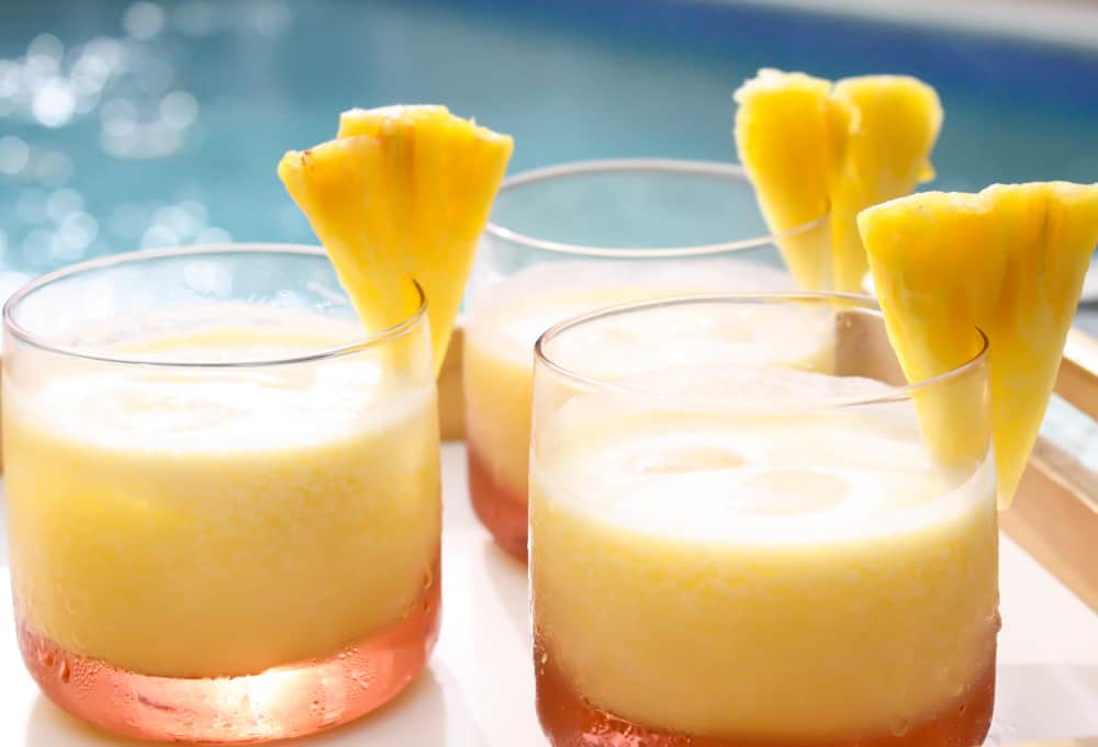 Pineapple coconut rum cocktail by a pool.