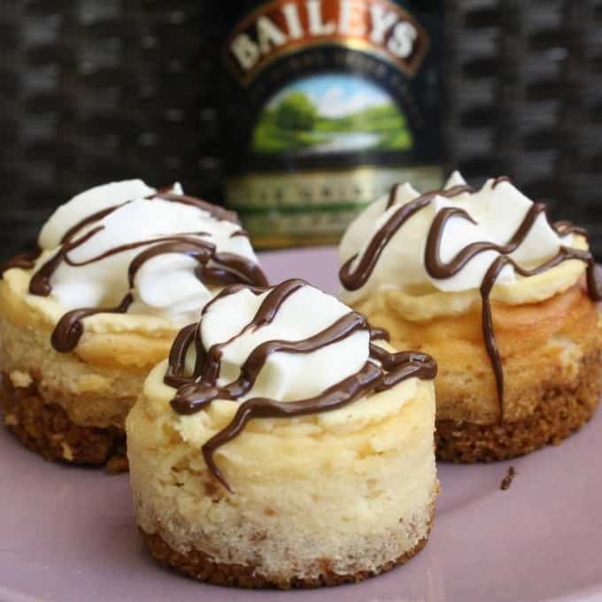 Three Mini Baileys Cheesecakes in front of a bottle of Bailey's