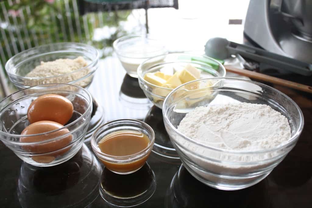 Wet and dry baking ingredients in bowls, on a table.