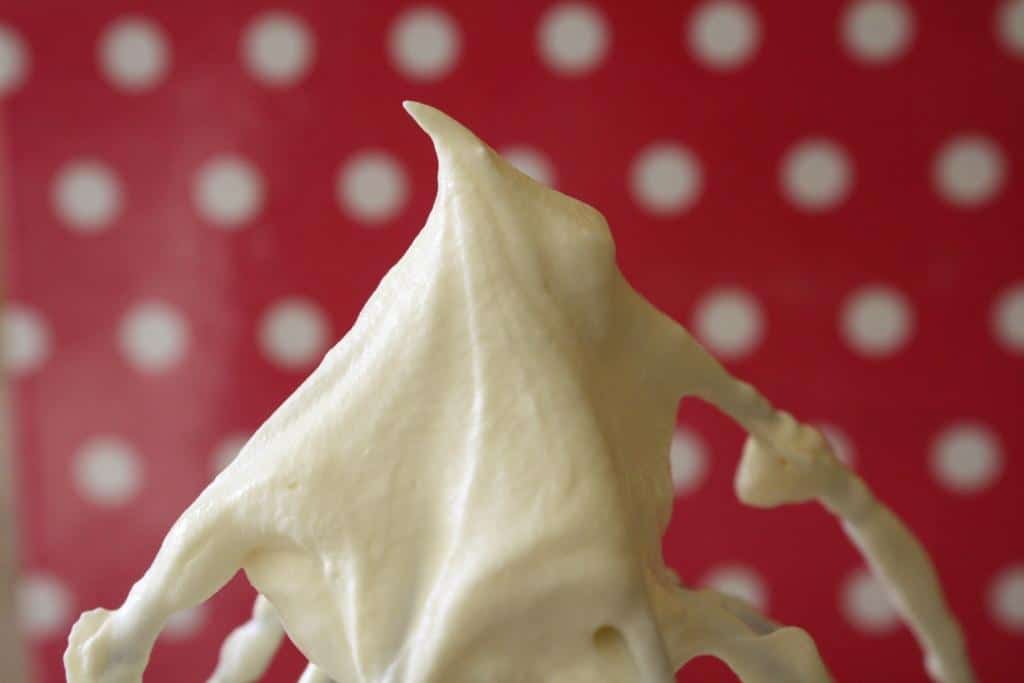 Whipped cream frosting on a whisk.