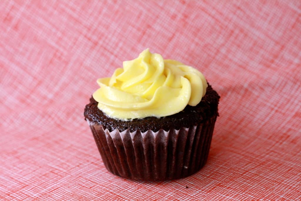 Side shot of cupcake with yellow frosting. 