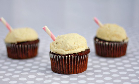 Three root beer cupcakes on a table.