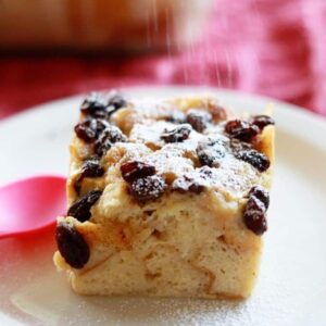 A slice of bread pudding on a white plate.