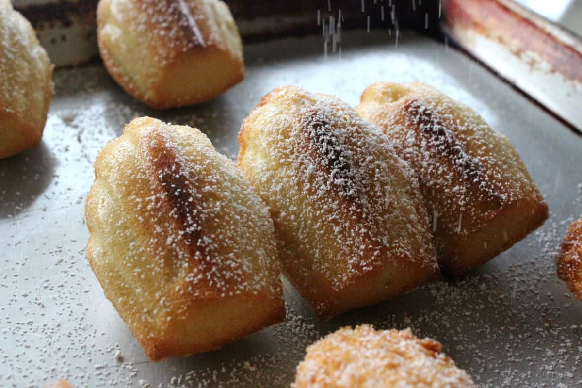 Sugar being dusted on baked cookies.