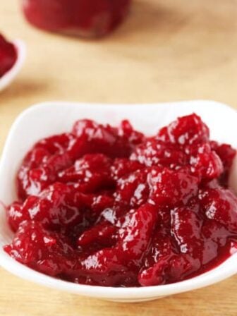 A white dish full of cranberry sauce.