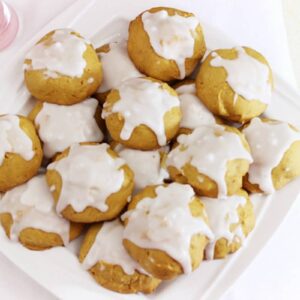 A batch of pumpkin cookies on a white plate.