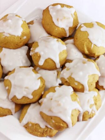 A batch of pumpkin cookies on a white plate.