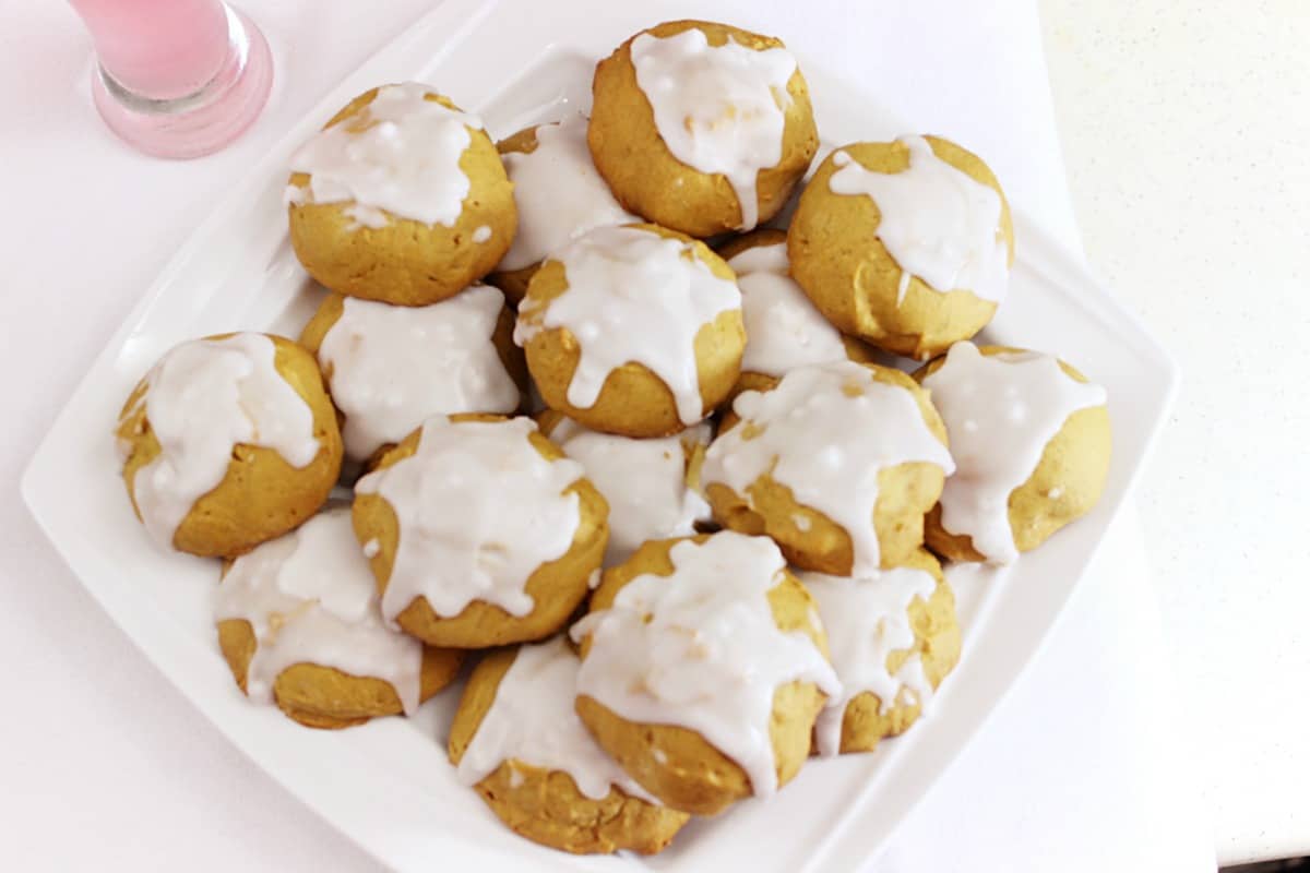 Top down shot of pumpkin cookies on a white dish.