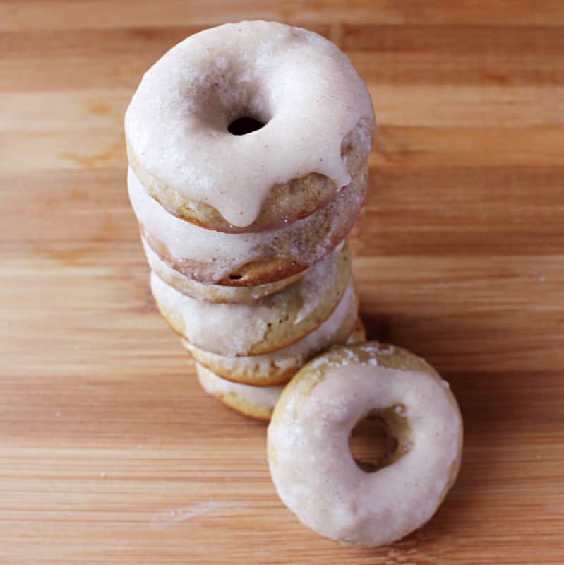 Top down shot of stack of doughnuts on a wooden table.
