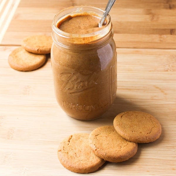 Cookie butter in a glass with cookies around it. 