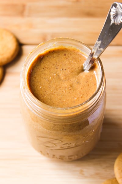 Overhead shot of cookie butter in a glass jar with a spoon.