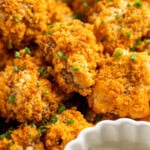 Cheesy buffalo cauliflower wings with bowl of vegan ranch. - 29