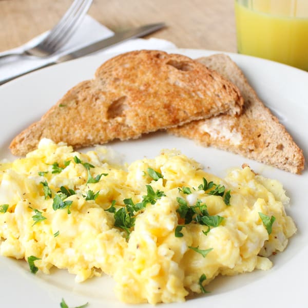 Toast and scrambled eggs on a plate.