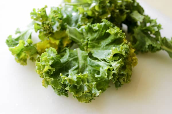 Kale leaves on white surface