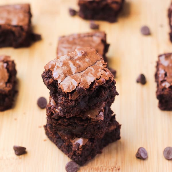 A stack of fudge brownies on a wooden table.