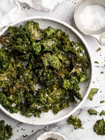 Bowl of baked kale chips with sea salt.