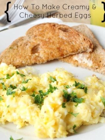 Herby scrambled eggs and toast on a white plate.