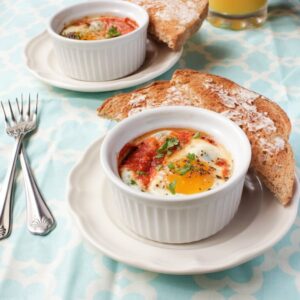 A ramekin with baked eggs in it.