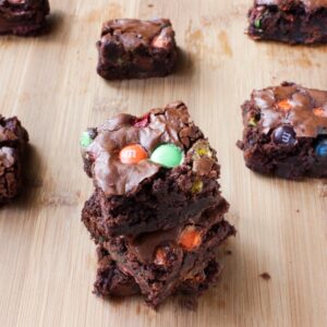 A batch of brownies on a wooden table.