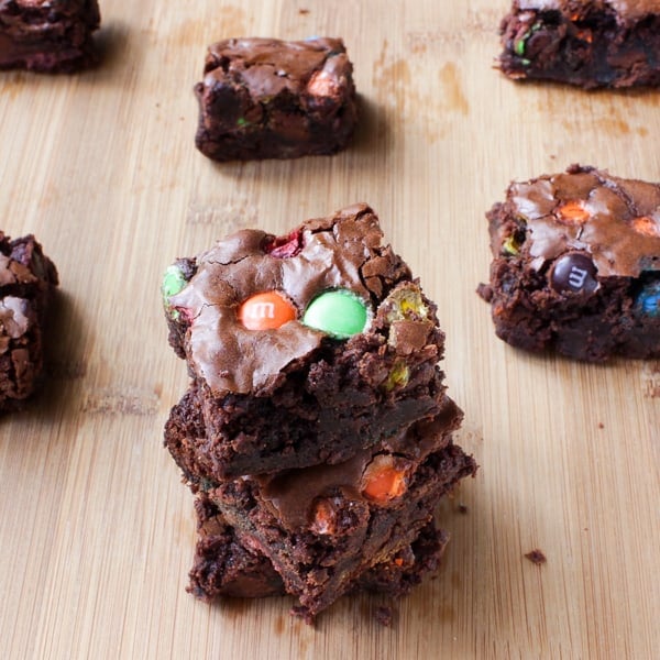 Stack of Double Chocolate M&M Brownies on a wooden table.