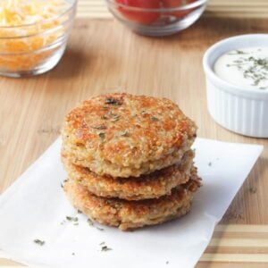 Stack Sundried Tomato and Mozzarella Quinoa Burgers on wooden table.