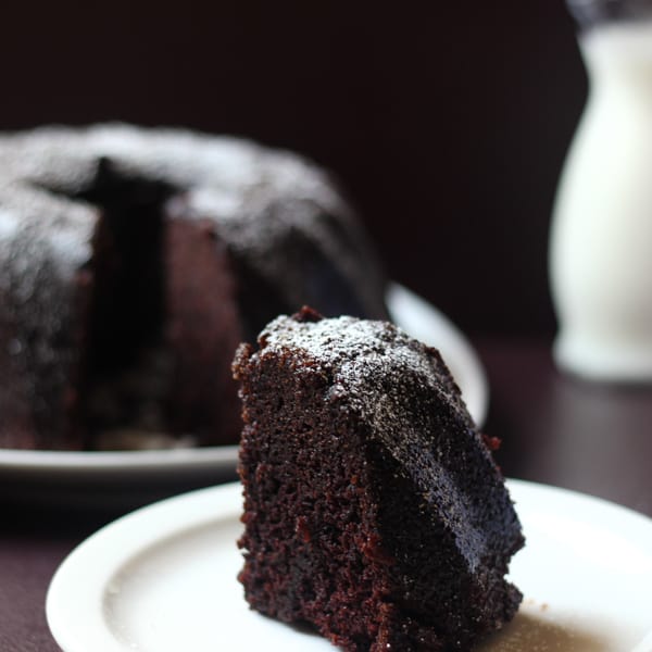 Close up of slice of chocolate cake on a white plate.