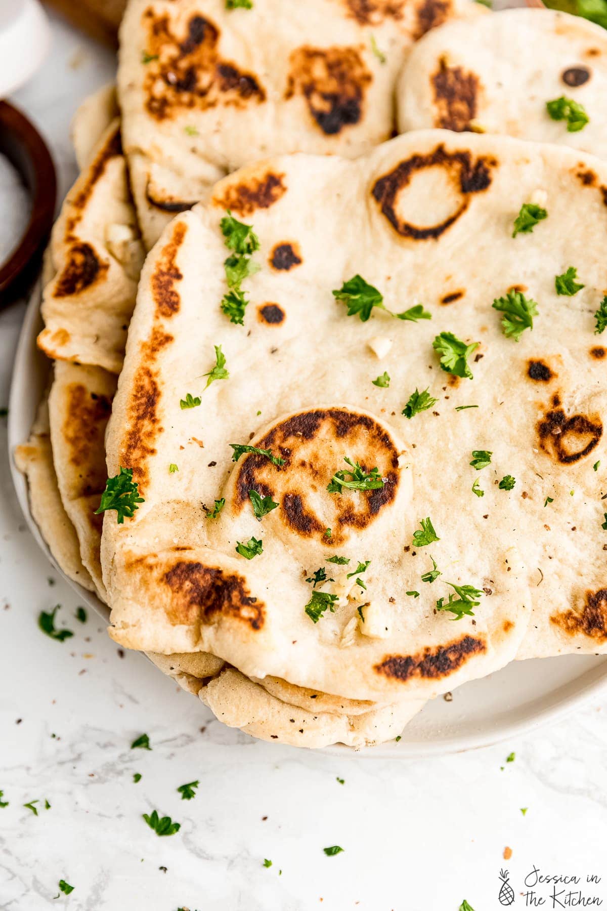 Stack of naan loaves on a plate.