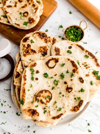 Overhead shot of stack of naan bread on a table.