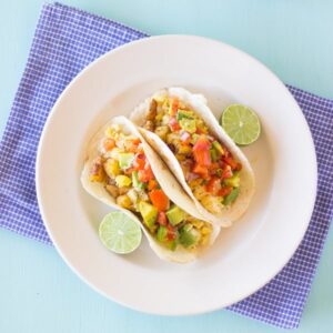 Top down shot of tacos on a white plate.