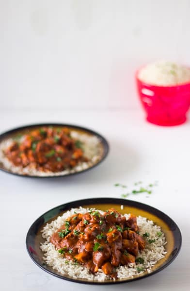 Healthy Indian Butter Chicken on a bed of white rice in a plate.