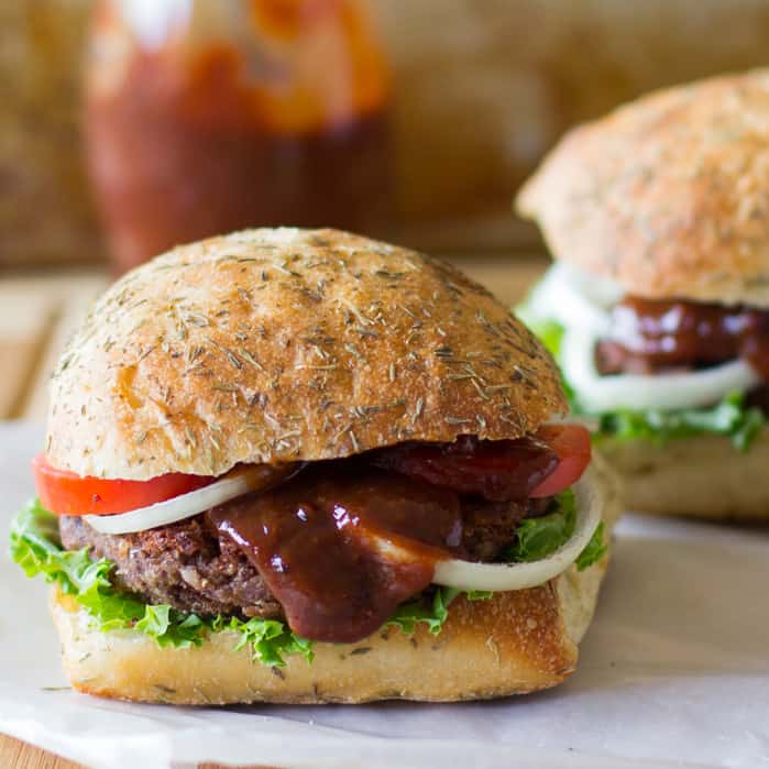 Side shot of black bean and quinoa burgers on parchment paper. 