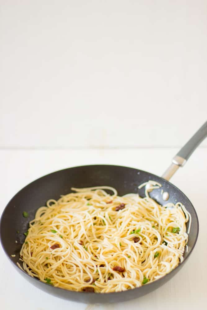 Lemon garlic spaghetti in a black skillet.