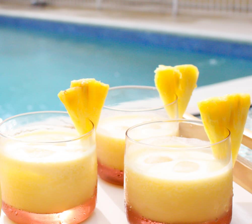 Three glasses of pineapple coconut rum cocktail by the pool.