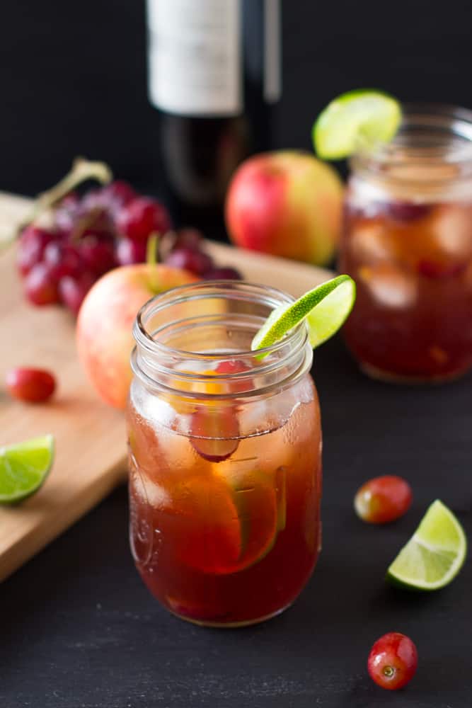 Rose sangria in a mason jar on a black table.