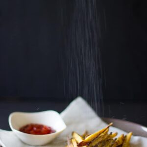 Salt falling on sweet potato fries
