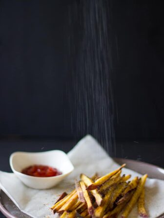 Salt falling on sweet potato fries