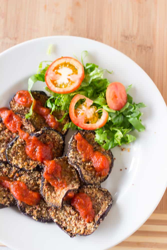 Overhead shot of almond crusted baked eggplant on a white plate.