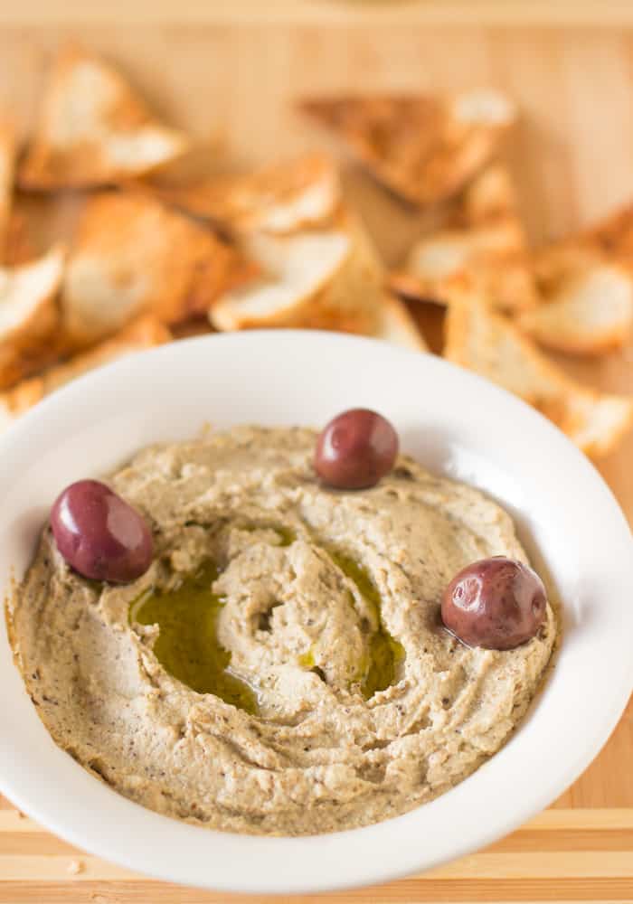 Baba Ghanoush in a white bowl with olives.