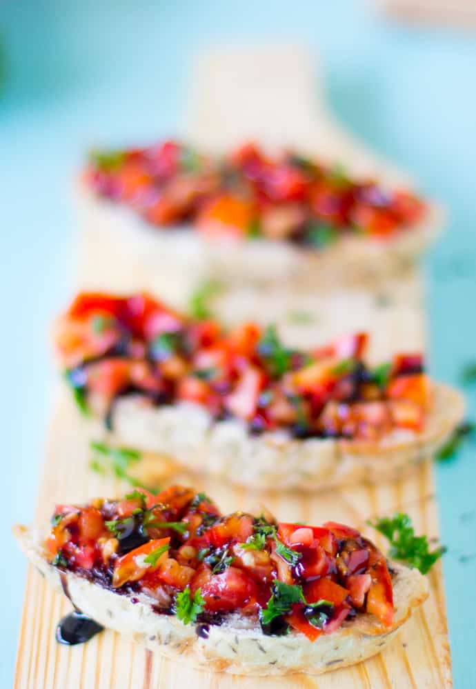 A row of bruschetta on a wooden plank. 