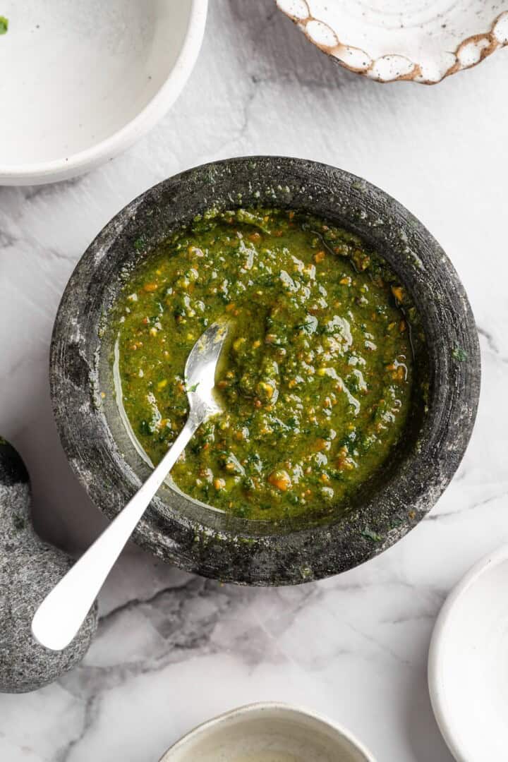 Pistachio pesto combines fresh basil leaves with nutty pistachios for a different spin on pesto. It's easy to make and so delicious! Mortar with pistachio pesto and spoon