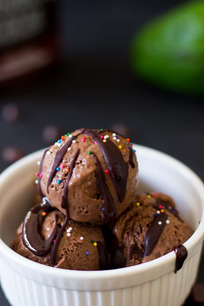 Three scoops of chocolate avocado ice cream in a white ramekin. 