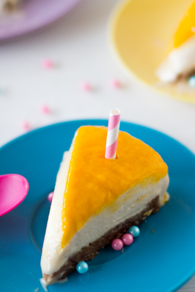 A slice of mango cheesecake on a blue plate. 