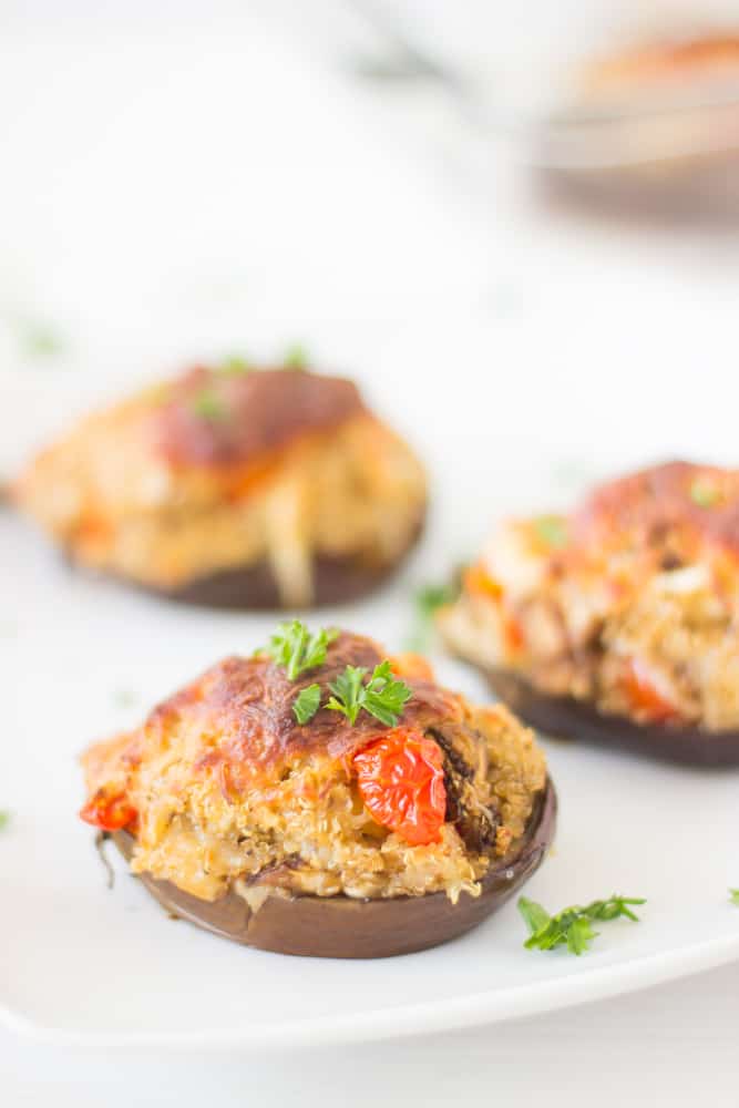 Cheesy Quinoa Stuffed Eggplants are packed with tons of delicious roasted veggies, quinoa, cheese and eggplant! You'll love this for a side dish or a full meal! #meatless #vegetarian #eggplant #summer