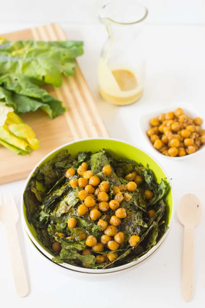 Overhead shot of crunchy kale & chickpea salad in a green bowl.