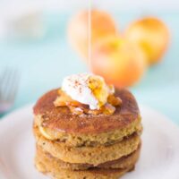 A stack of apple pie pancakes on a white plate.