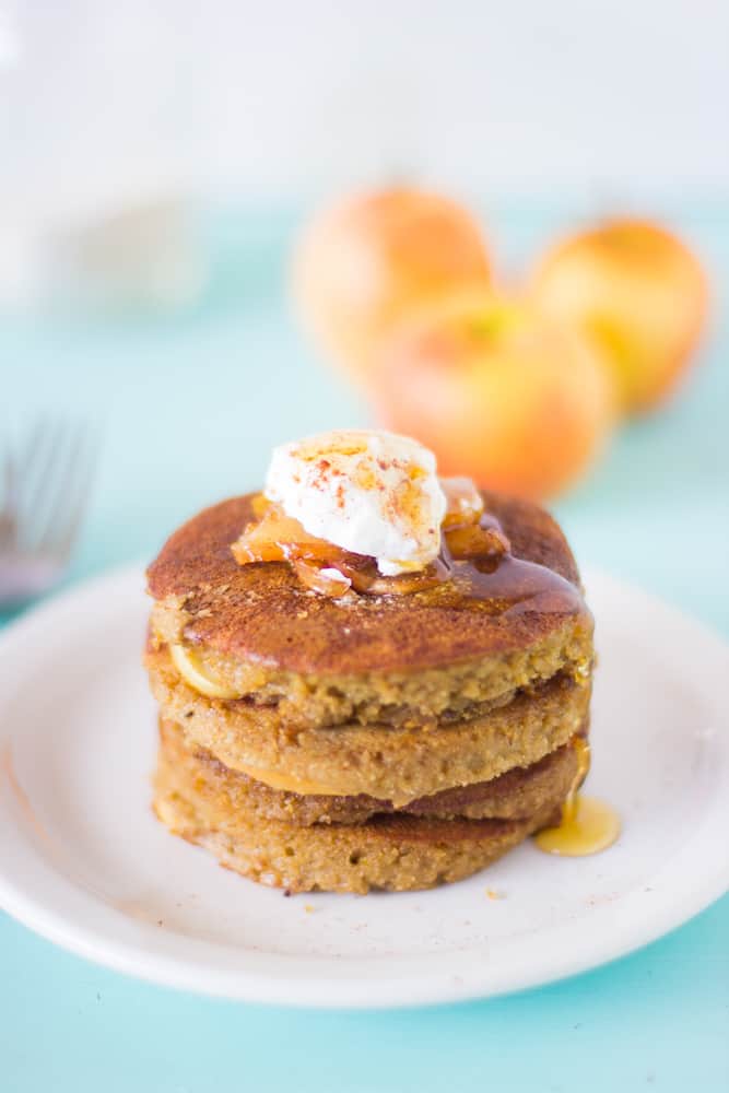 Three pancakes stacked on a white plate.