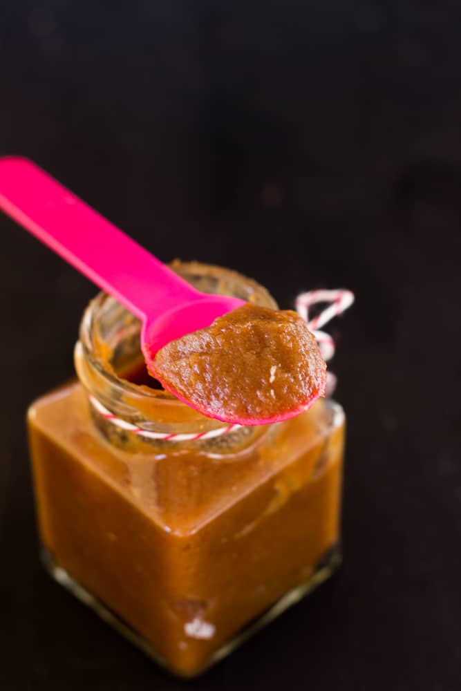 Date syrup on a pink spoon.