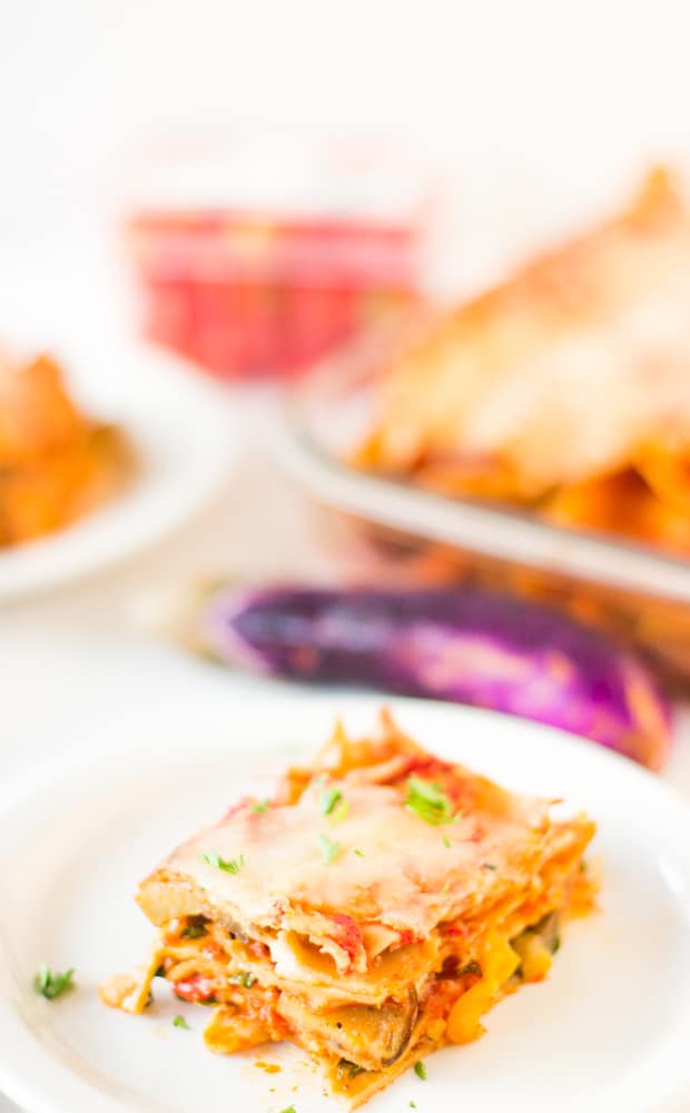 A square of lasagna on a white plate. 