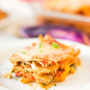 Close up of a lasagna slice on a white plate.