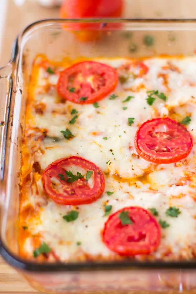 Close up of cauliflower pizza casserole in a glass baking dish. 